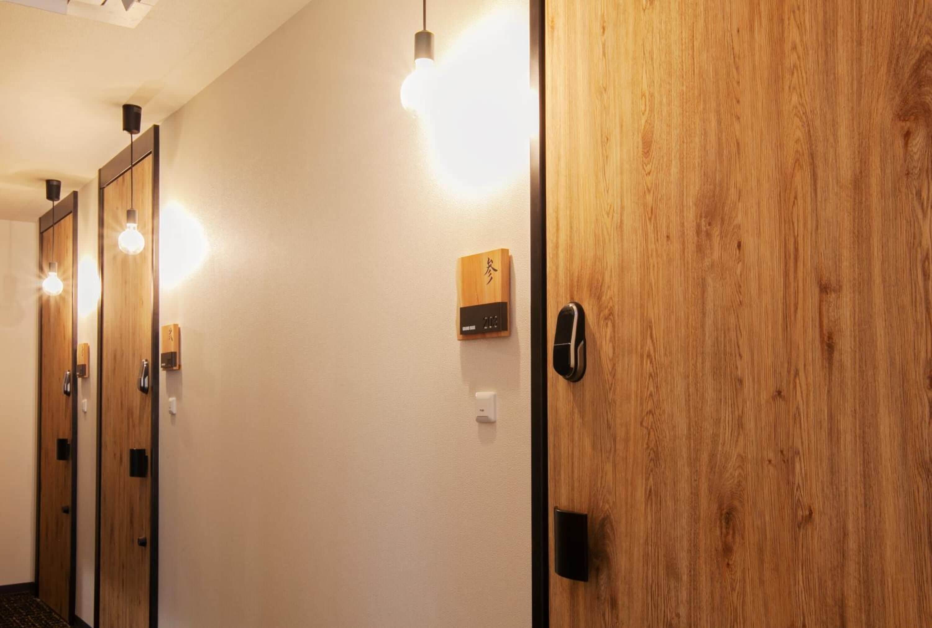 A hallway with wooden doors, a wall-mounted light, and a small wooden plaque.