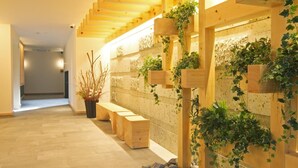 A wooden staircase with benches and climbing plants. - GRAND BASE Osu (Nagoya)