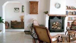 A cozy living room with a fireplace, wooden furniture, and a bookshelf. - Las Chimeneas (Nevada)