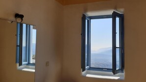 A room with two windows, one open, offering a view of distant mountains. - Las Chimeneas (Nevada)