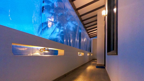 A hallway with a wooden floor, a large wall mural, and recessed lighting. - Wagon Wheel Inn - Hostel (Boossa)