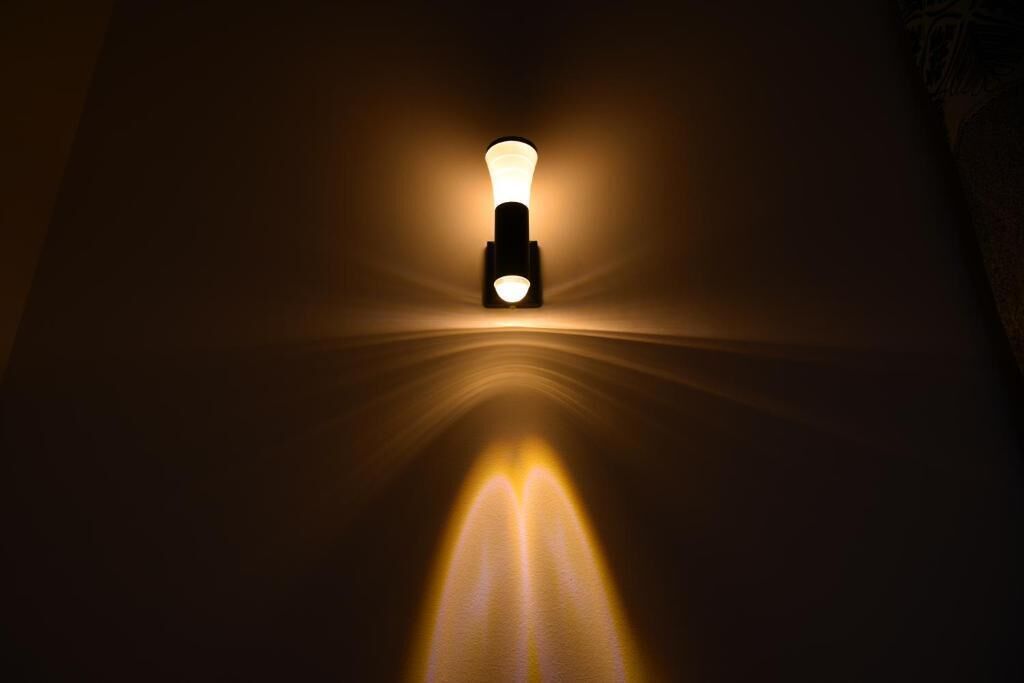 A wall-mounted light fixture with a focused beam of light.