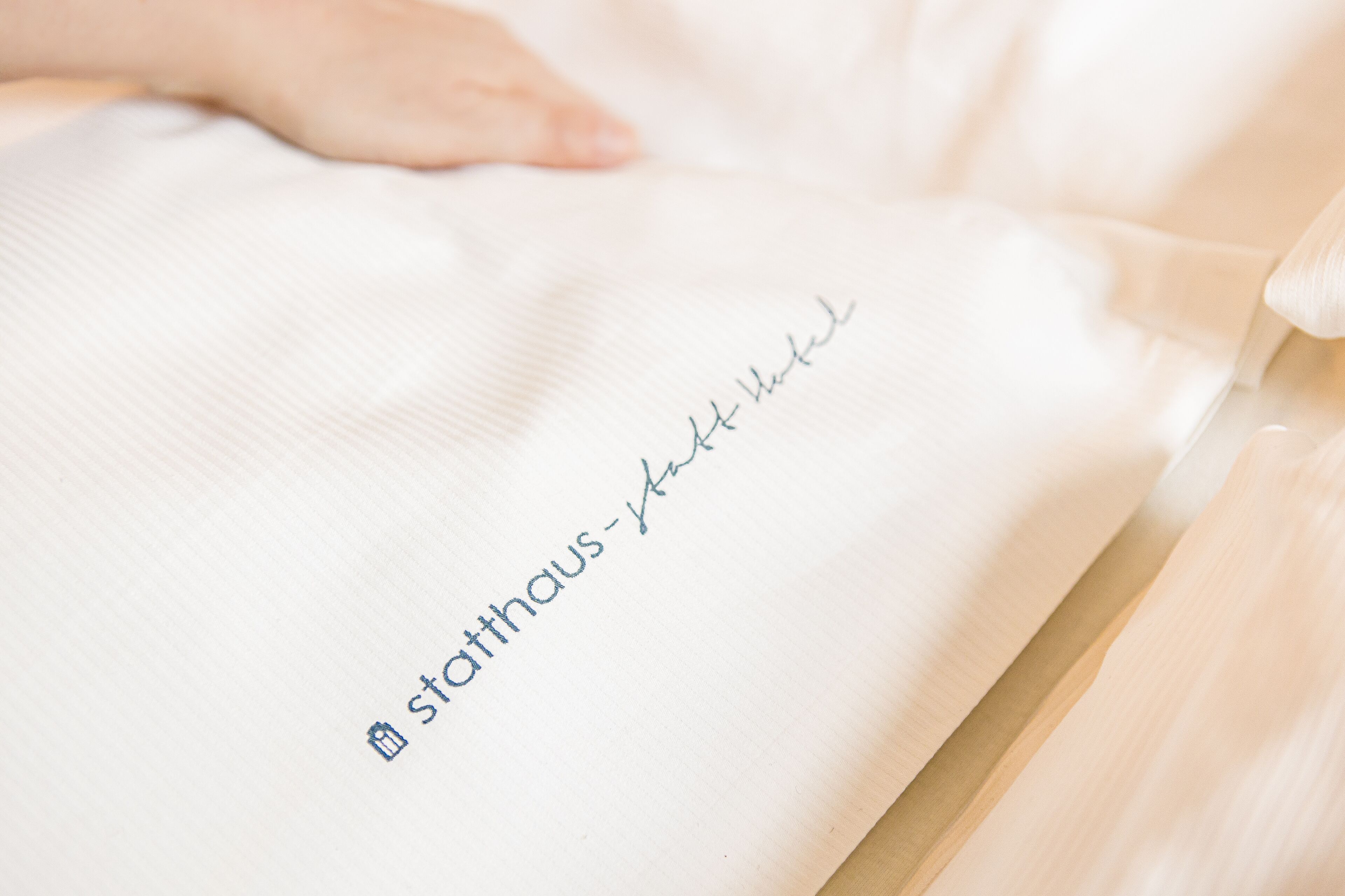 Ein weißes Gewebe mit dem Schriftzug "starthaus-klett hotel" und einem kleinen Symbol.