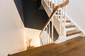 Un escalier avec des balustrades blanches et des marches en bois.