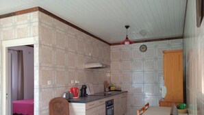 A compact kitchen with a dining area, featuring a wooden cabinet, a sink, and a dining table with chairs. - Apartment for 2 people  (La riviere saint louis)