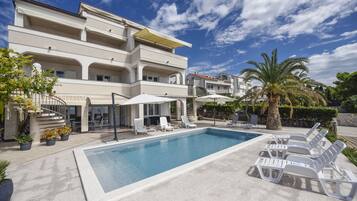 Sesongbasert utendørsbasseng, bassengparasoller og solsenger