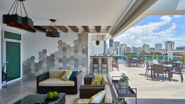 Un salon moderne avec vue sur la ville, comprenant un canapé, une table basse et un coin repas.