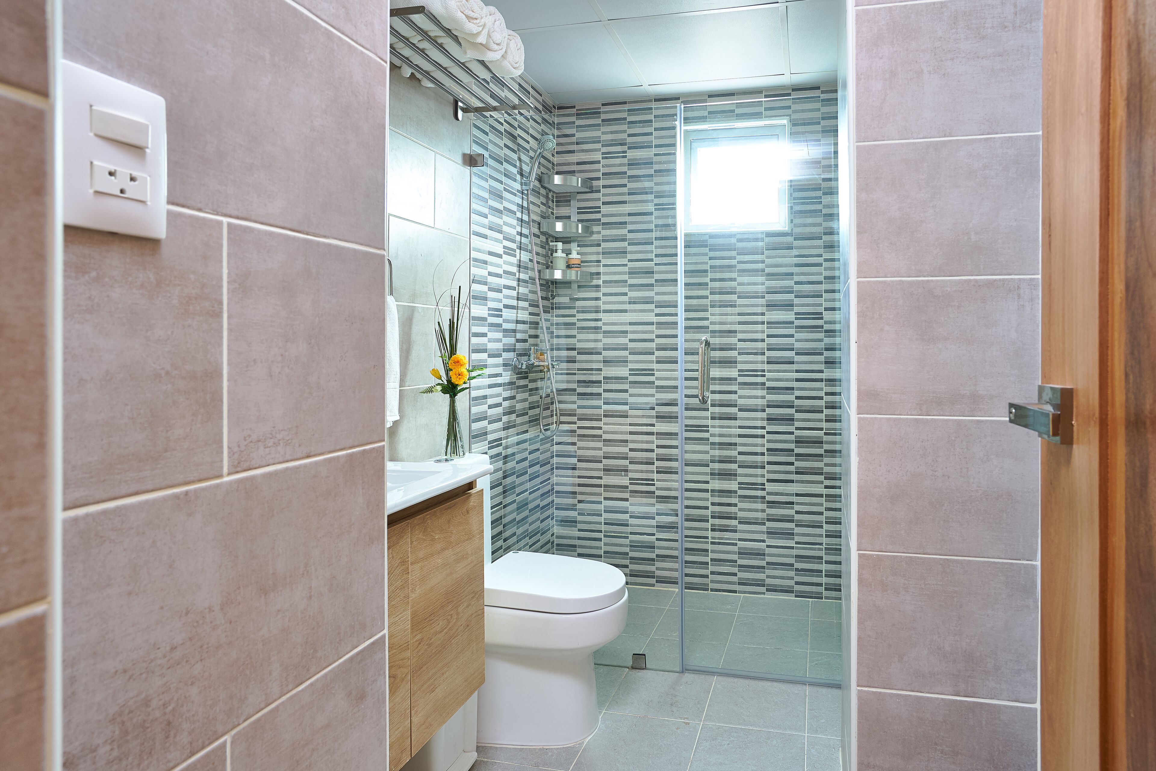 Un baño moderno con inodoro, lavabo y zona de ducha.