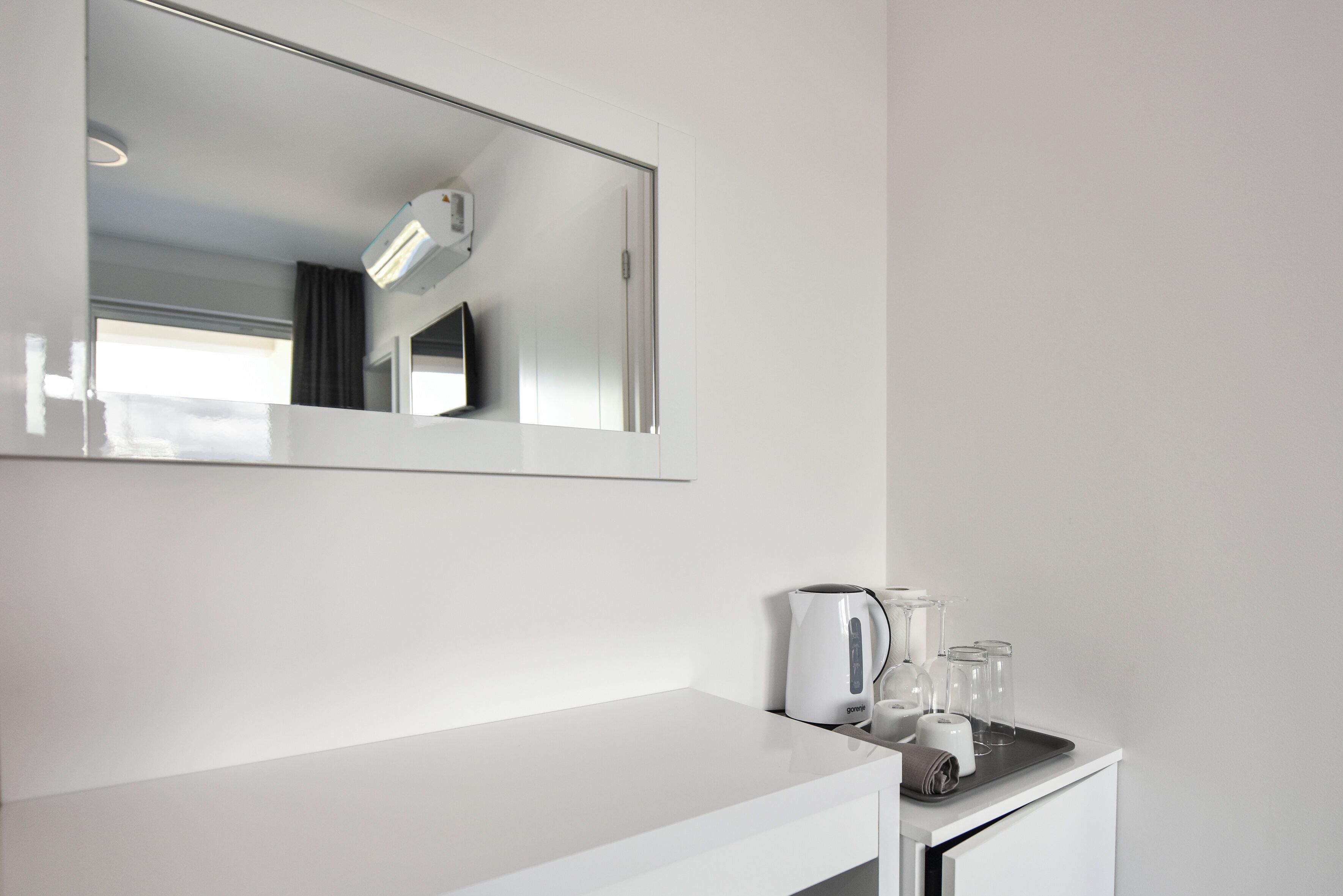 Une salle de bain moderne avec un meuble-lavabo blanc, un miroir, un porte-serviettes et un distributeur de serviettes.
