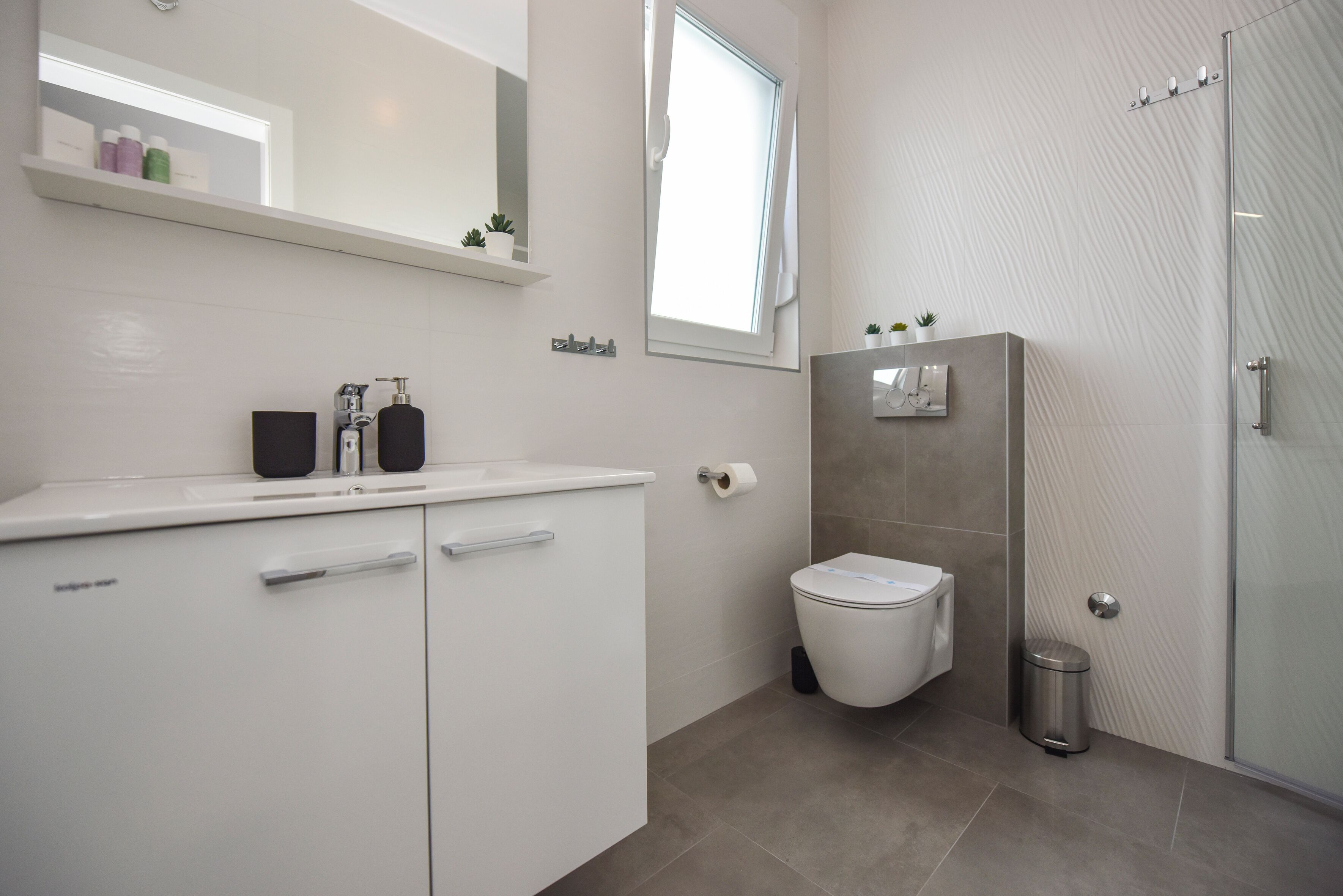 Un baño moderno con inodoro, lavabo y ducha.