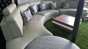 A curved sofa with zebra-patterned cushions, a wooden coffee table, and a tented structure in the background. - Sodere Resort Hotels Africa Union (Addis Ababa)