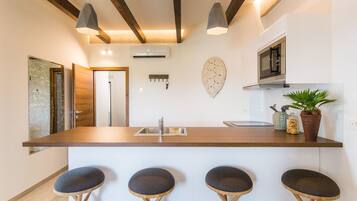 Deluxe Apartment | Private kitchen | Mini-fridge, electric kettle, highchair, cookware/dishes/utensils