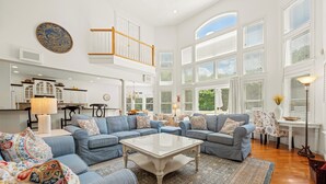 A spacious living room with a sectional sofa, a coffee table, and a patterned rug.