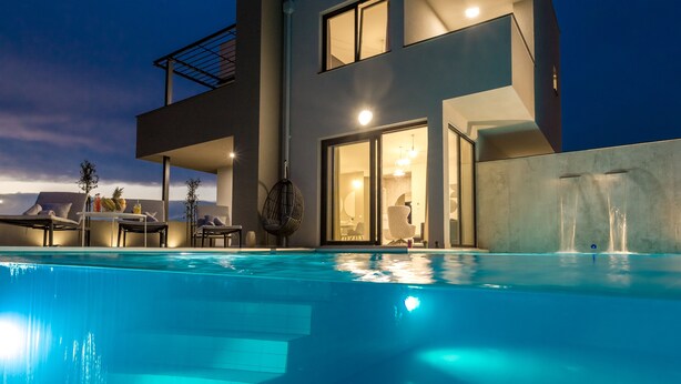 A modern house with a swimming pool, outdoor seating, and a large glass door leading to the interior. - Villa Sara (Novalja)