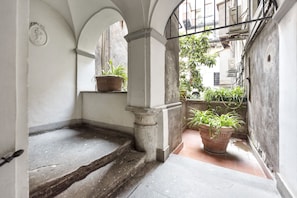 Stairway to a serene outdoor oasis, lined with lush greenery and a decorative emblem.