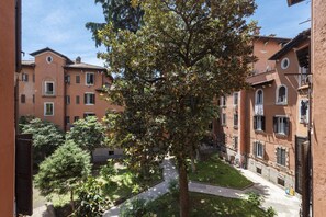 Un patio con un árbol, rodeado de edificios con balcones y ventanas.
