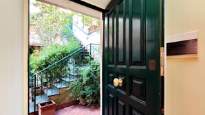 Una puerta verde con pomo de latón, un buzón y una pequeña ventana a la derecha.