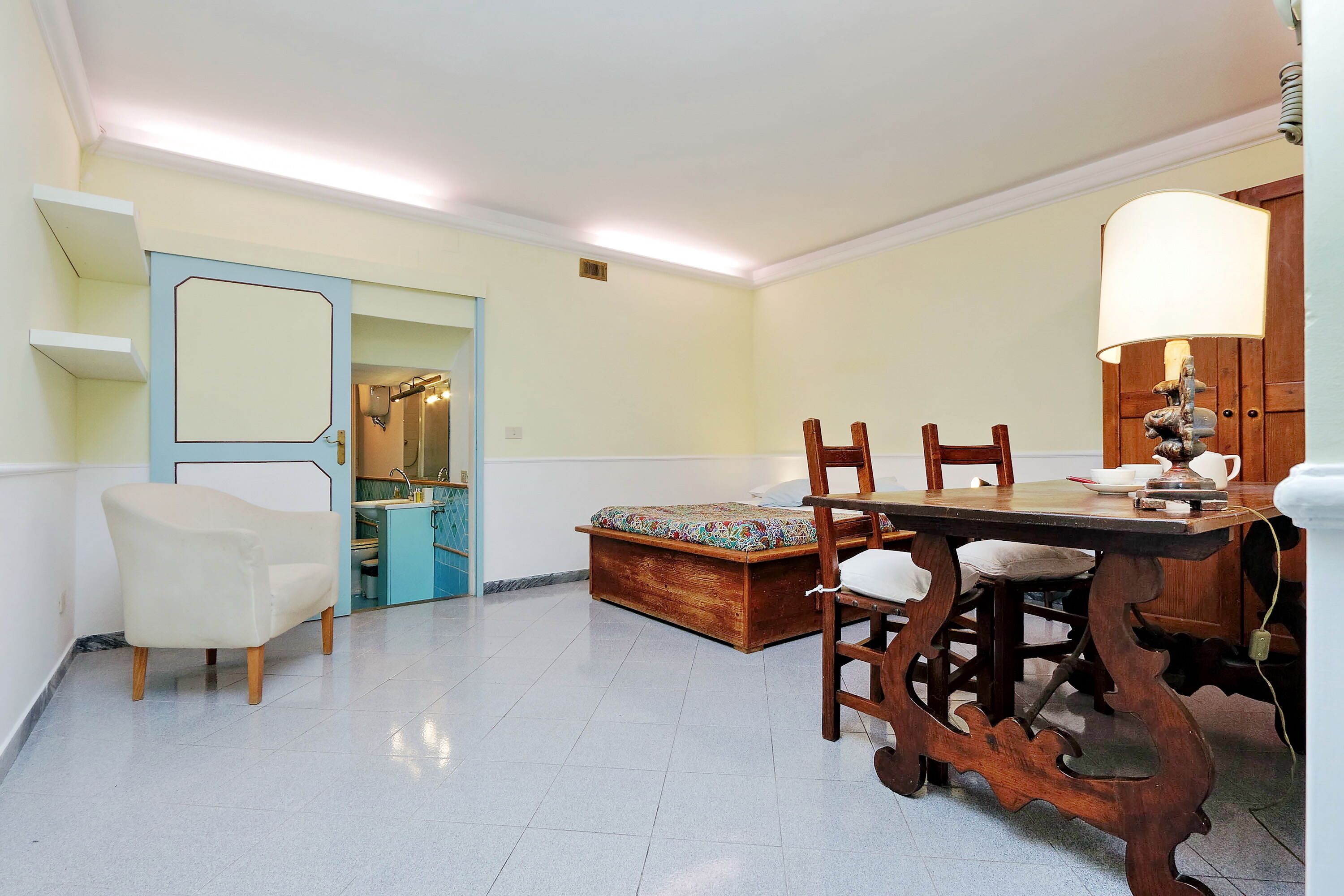Un comedor con una mesa y sillas de madera, un sofá y una lámpara.