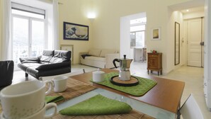 A modern living room with a sofa, a coffee table, and a dining area with a table and chairs. - Seiano (Vico Equense)