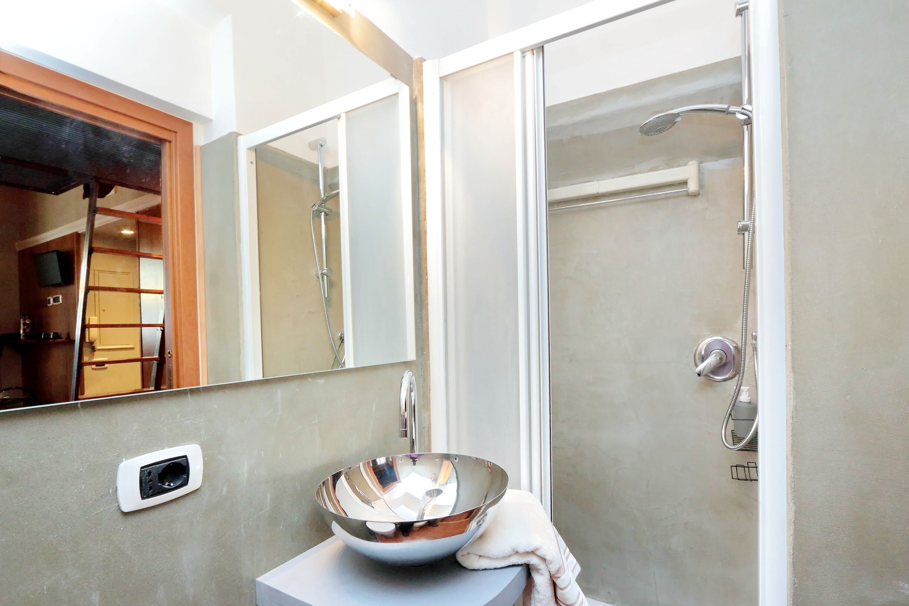 Un baño con un espejo grande, un lavabo y una cabina de ducha.