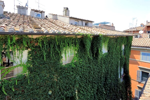 A building with a tiled roof and ivy-covered walls. - Volpe (Rome)