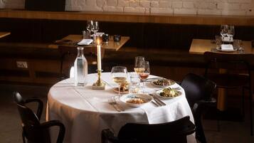 Une table de restaurant mise avec des assiettes, des verres et une bougie.