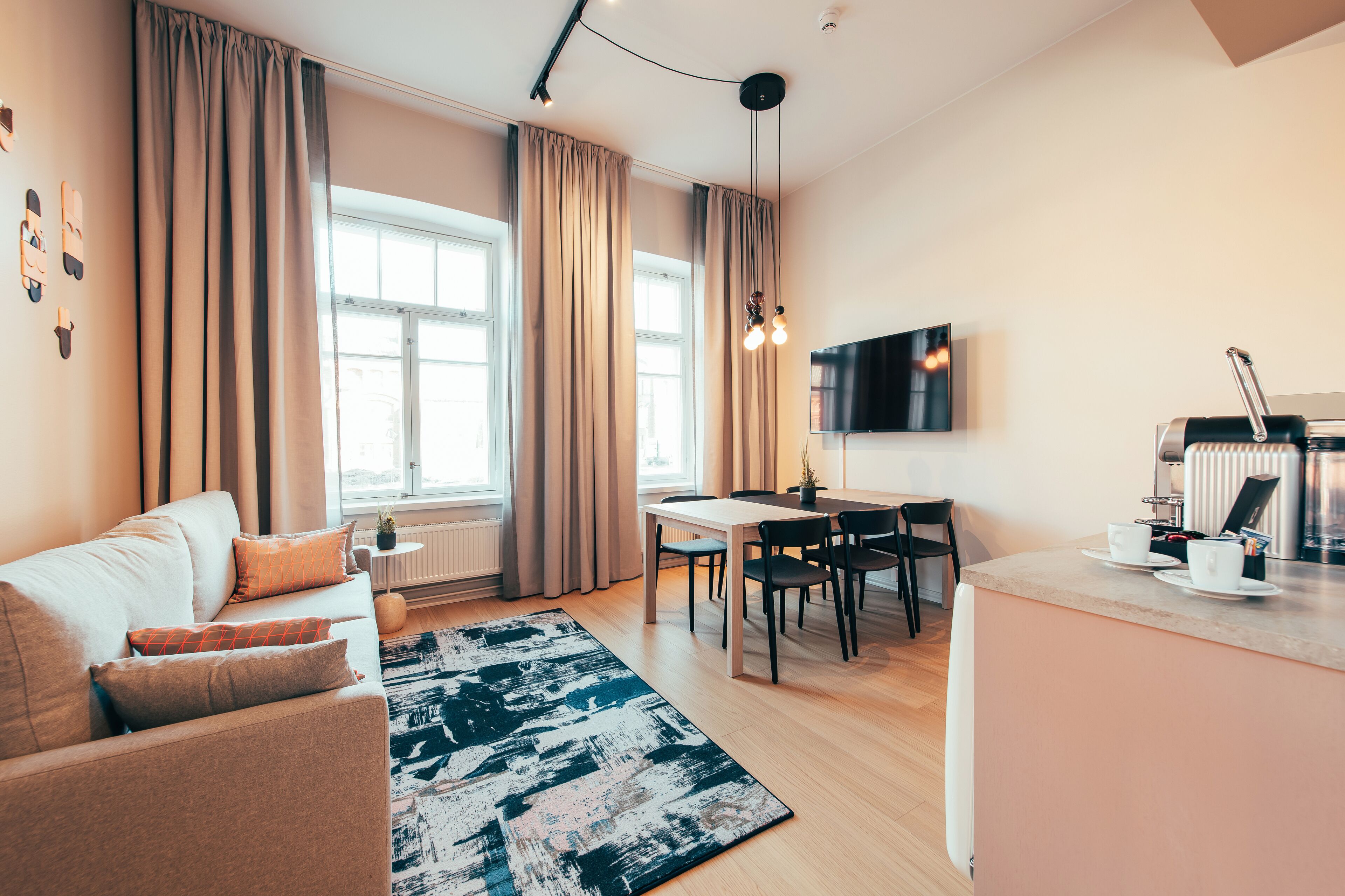 Een moderne woonkamer met een bank, eettafel en keuken.