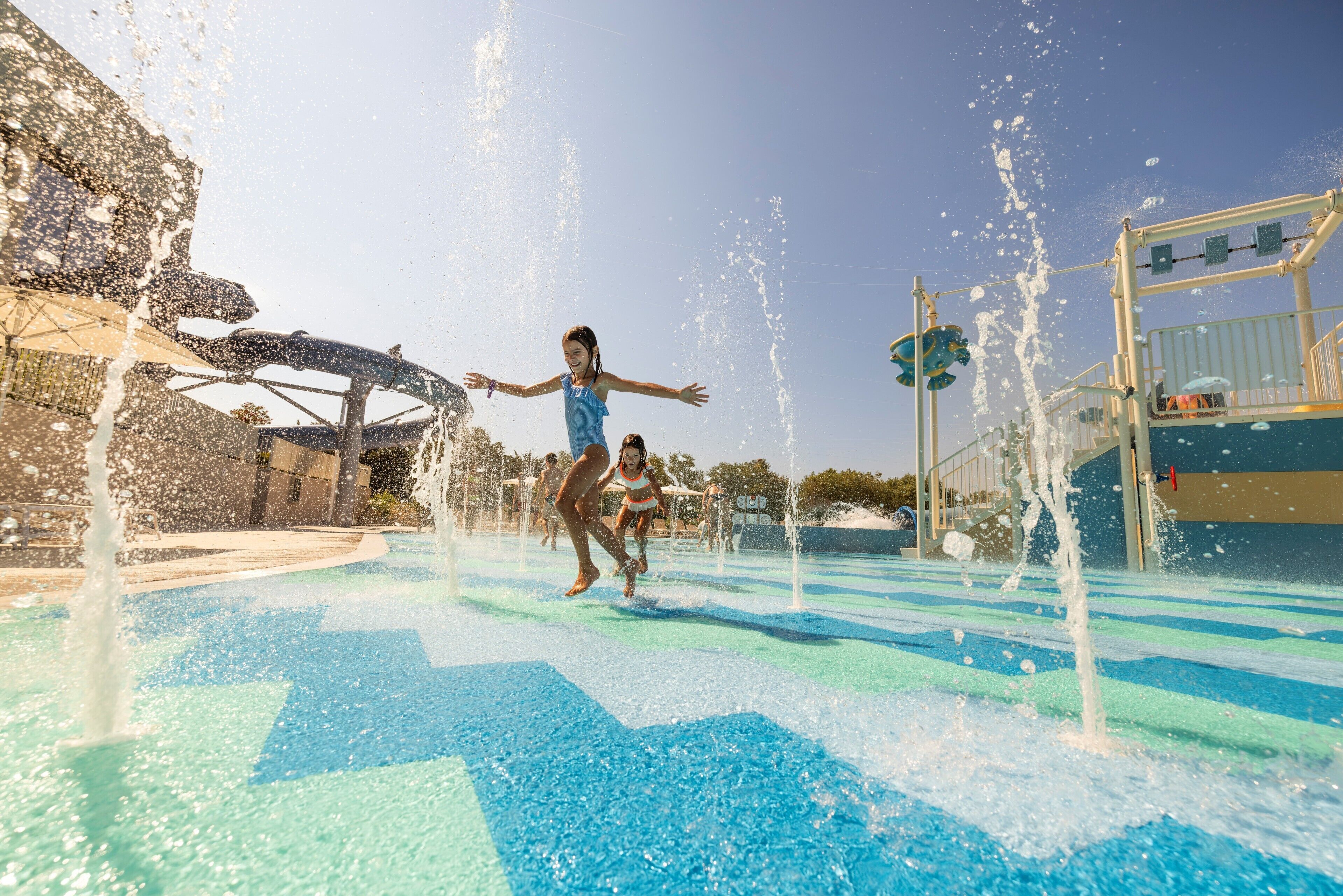 A water play area with multiple water jets and a slide.