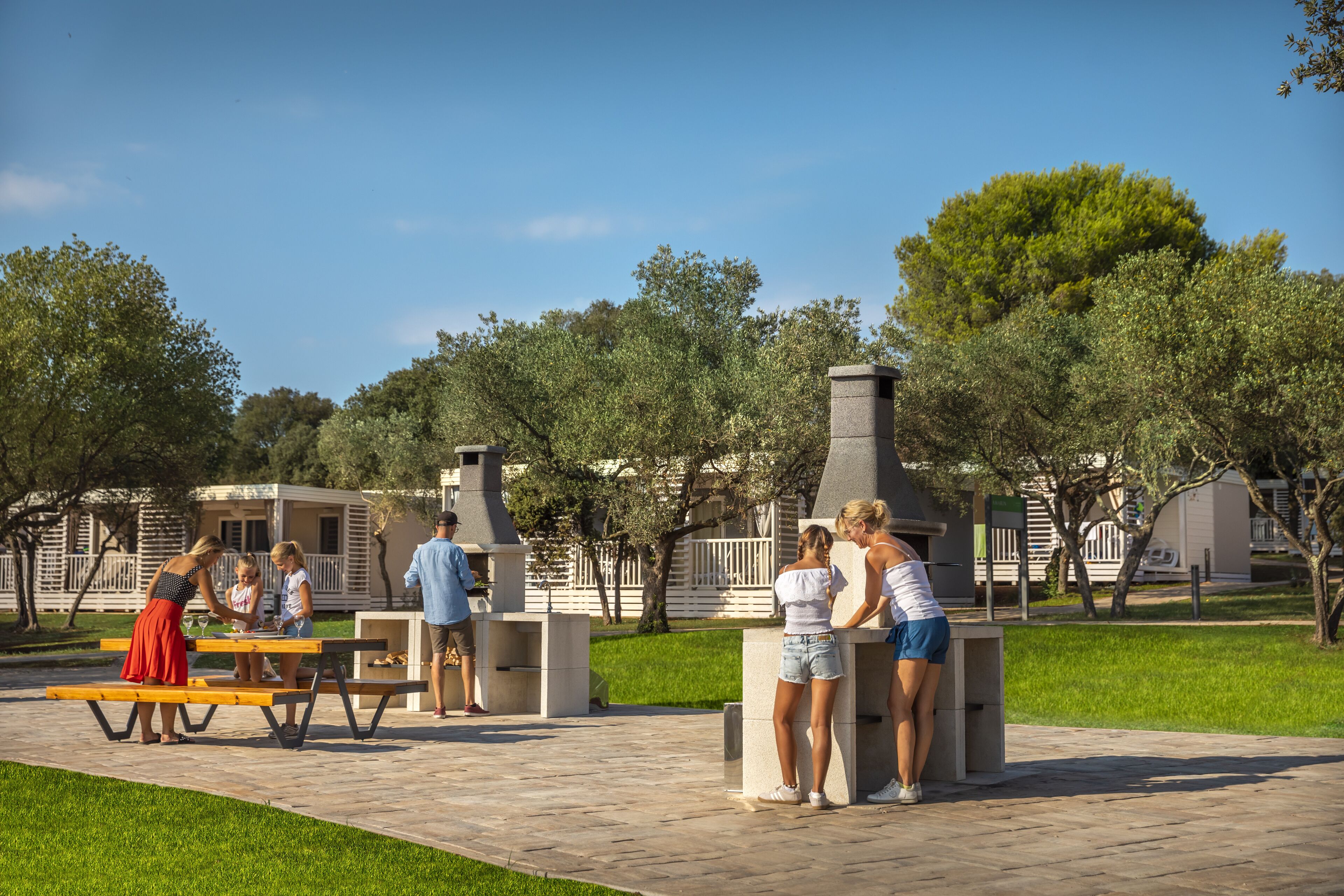 A patio area with picnic tables and a barbecue grill.