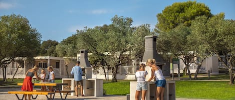 A patio area with picnic tables and a barbecue grill.