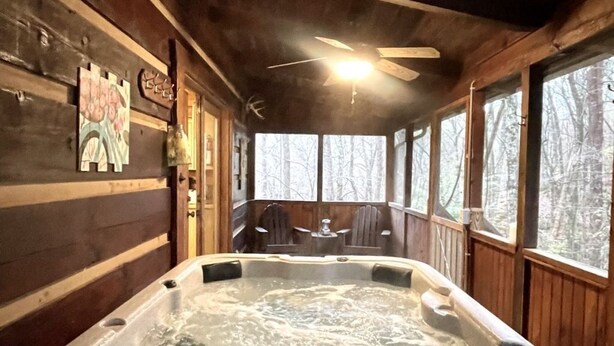 A wooden cabin interior with a hot tub, wooden walls, and large windows. - Leave the stress behind!- private hot tub, pet and motorcycle friendly, let peace and nature surround you! 2 Bedroom Home by RedAwning (Tellico Plains)