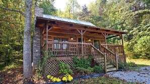 A rustic cabin with a porch, wooden stairs, and a lattice fence. - Leave the stress behind!- private hot tub, pet and motorcycle friendly, let peace and nature surround you! 2 Bedroom Home by RedAwning (Tellico Plains)