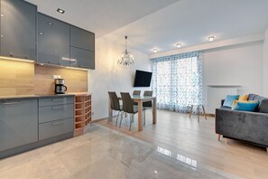 Appartement Deluxe | Salle de séjour | Télévision à écran plat de 42 pouces avec chaînes par câble, télévision