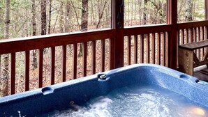 A hot tub in a wooden deck with a forest view. - Private and Perfect! - hot tub, king bed, fireplace - dog and motorcycle friendly Studio Cabin by RedAwning (Tellico Plains)