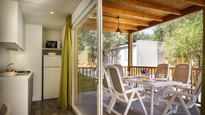 A kitchen with a microwave, refrigerator, and a dining area with a table and chairs.
