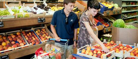 Un supermercado con diversas frutas y verduras exhibidas.