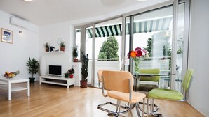 A modern living room with a TV, a glass table, and two chairs. - Marimari Apartment, 4th floor with elevator (Split)