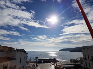 A coastal view with buildings, a pier, and a clear sky. - Hotel La Residencia (Cadaqués)