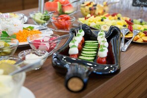 A buffet table with various food items including skewers, salads, and fruits. - Weingut Schreieck VINOTEL & GUTSHAUS (Sankt Martin)