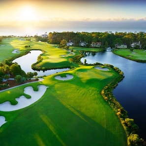 A golf course with sand bunkers, water hazards, and a clubhouse in the background. - 5th Fl Ocean/Beach Views 1BR/2BA Sleeps 4/New King Mattress/Sofa Bed/Jacuzzi Tub (Hilton Head Island)