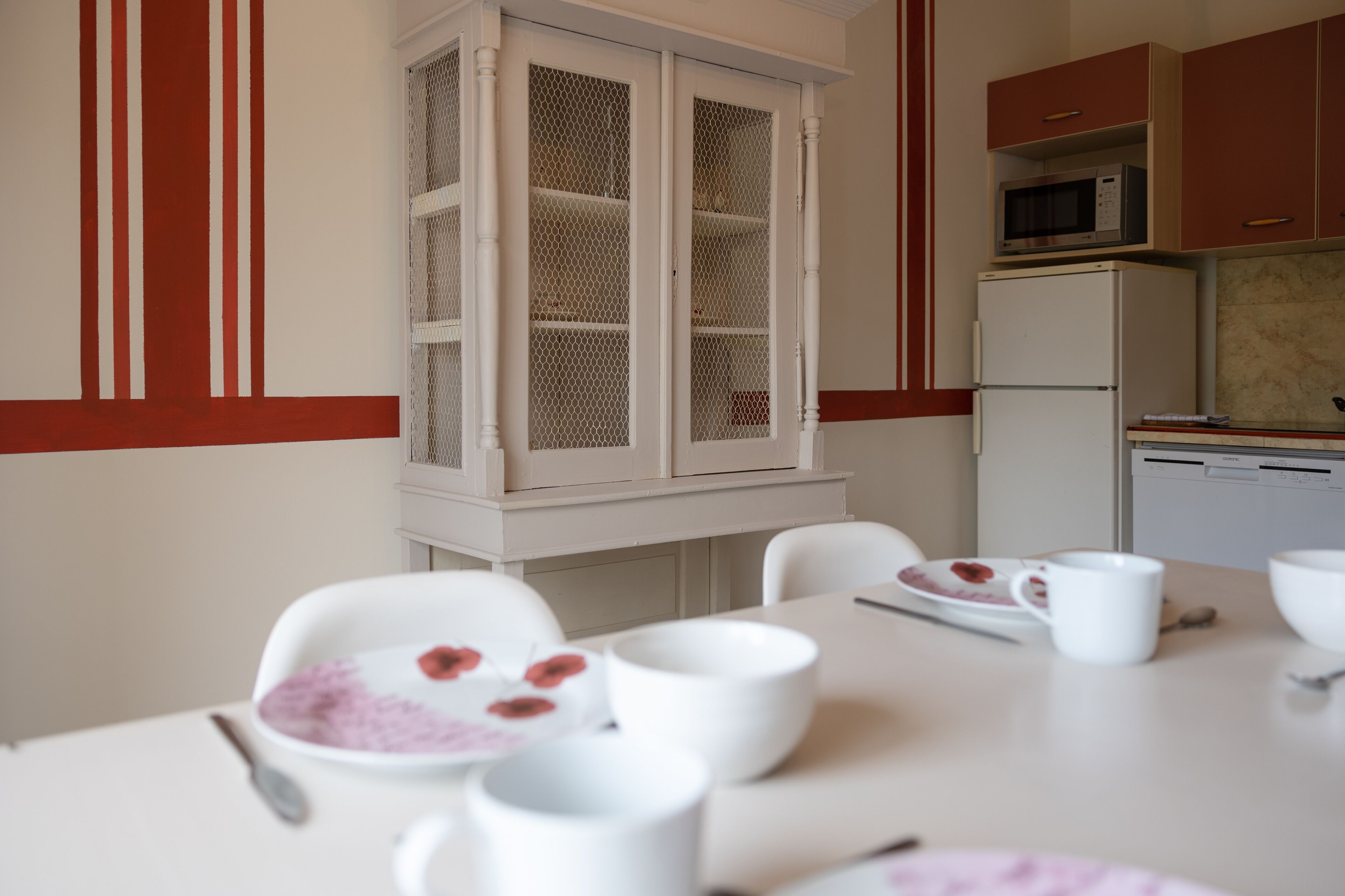 A kitchen with white cabinets, a microwave, and a refrigerator.