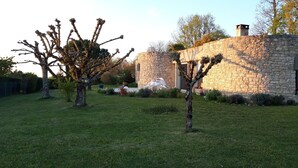Un edificio de piedra con una pequeña ventana de arco y una chimenea.