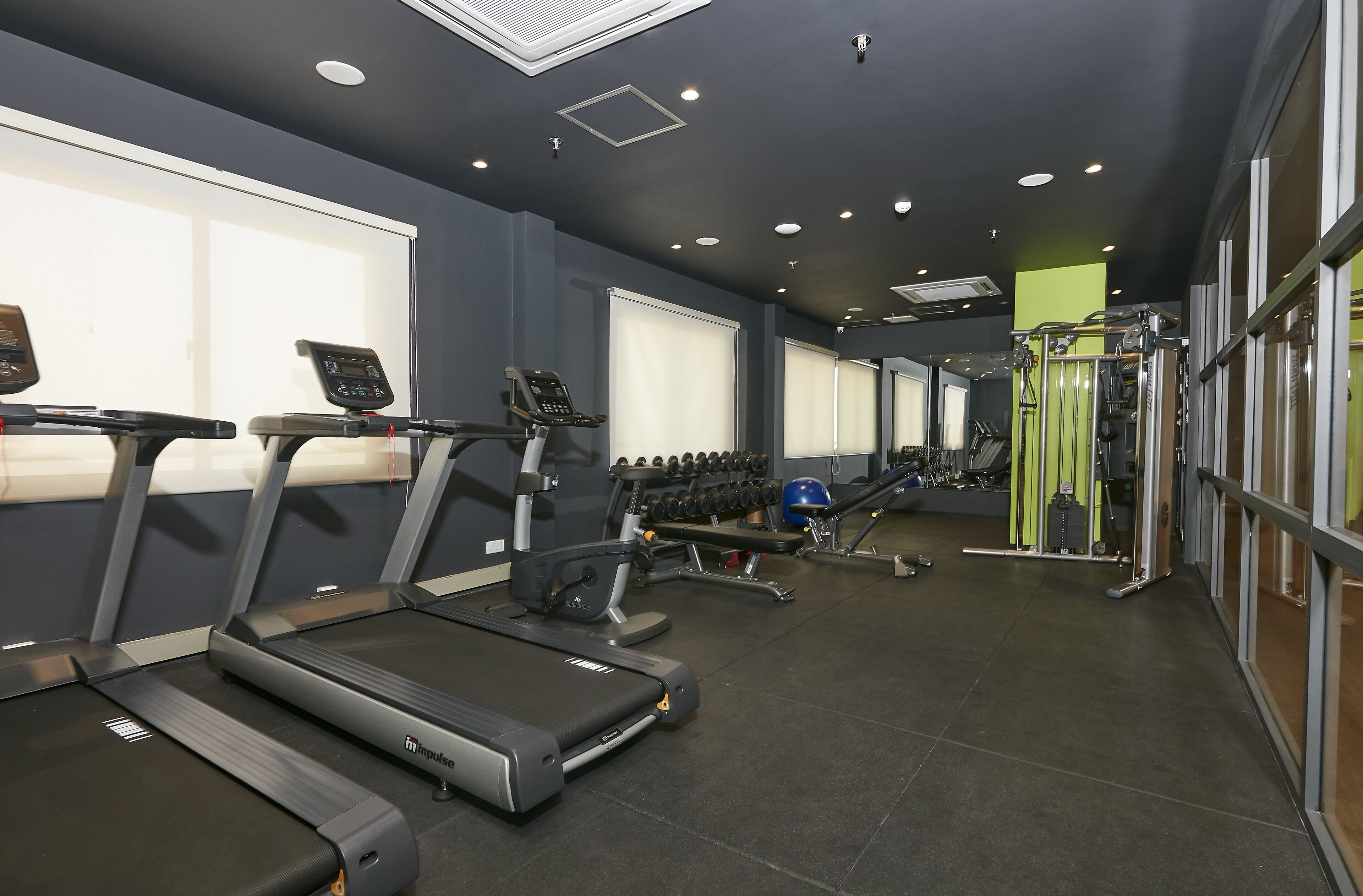 Un gimnasio con cintas de correr, mancuernas y máquinas de pesas.