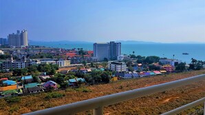 A coastal cityscape with various buildings, including high-rise apartments and smaller residential structures. - Sea Views at Jomtien Beach (Pattaya)