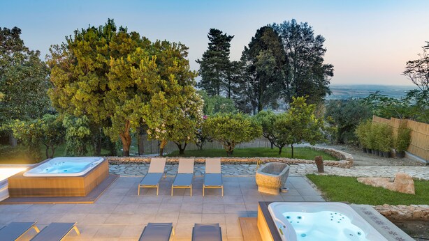 An outdoor hot tub area with lounge chairs and a stone pathway. - Luna del Raccolto (Valderice)
