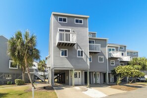 A multi-story residential building with balconies, a covered entrance, and a palm tree in the foreground. - Gulf/Gazebo View! Recently Remodeled! Just steps from Gulf Non-smoking, No Pets! (Port St Joe)