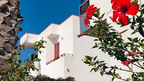 A white building with a sign indicating it is an apartment for rent. - A few steps from the crystal clear sea of Puglia (Lido Marini)
