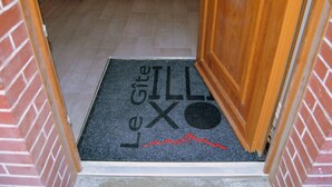 A doormat with the text "Le Gîte Illo" and a red line.