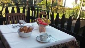 A table set with breakfast items including bread, a fruit basket, and a coffee cup.
