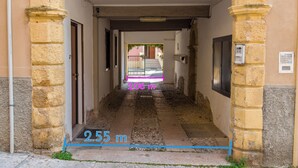 A corridor with stone walls and a sign indicating a height of 2.55 meters.